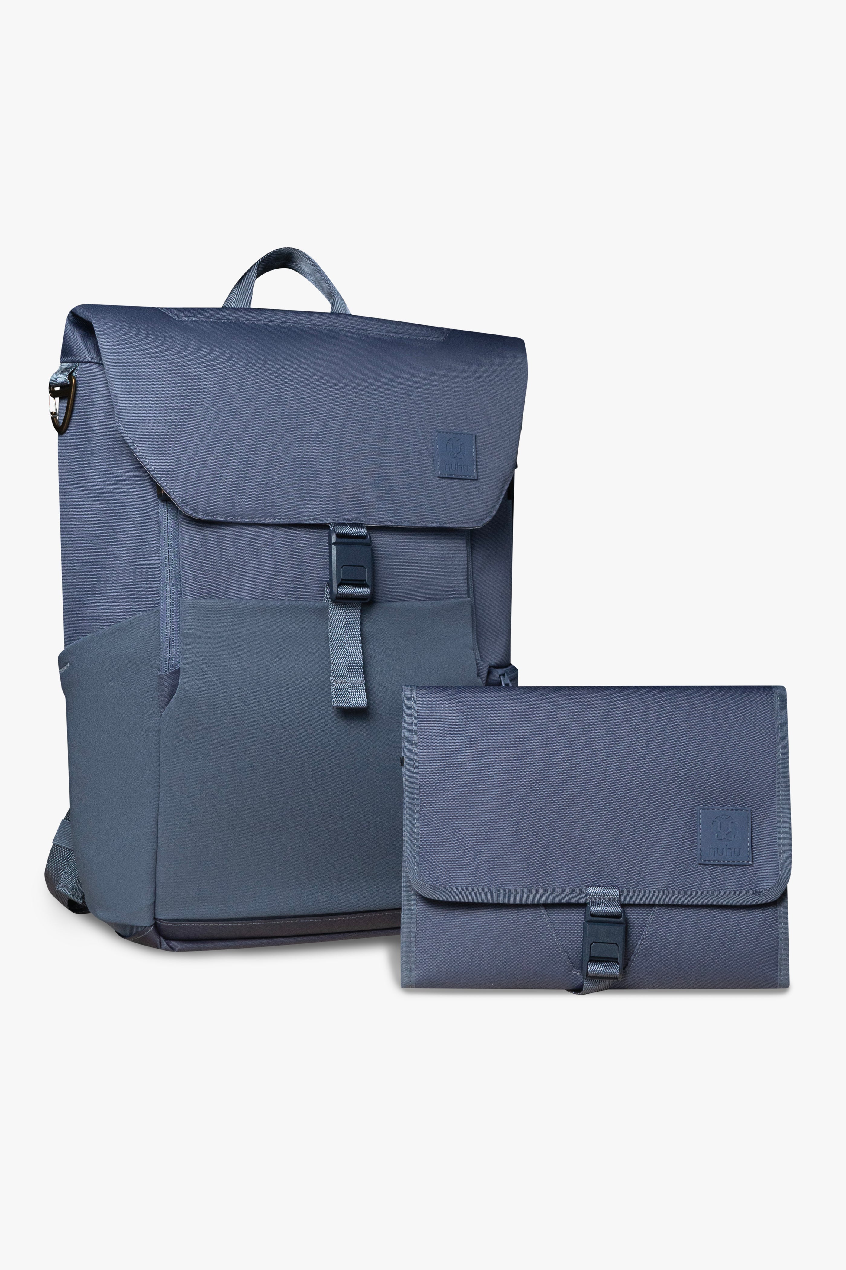 Front view of blue backpack and changing wallet. Both are closed, and show magnetic clasp and exterior of products against white background.