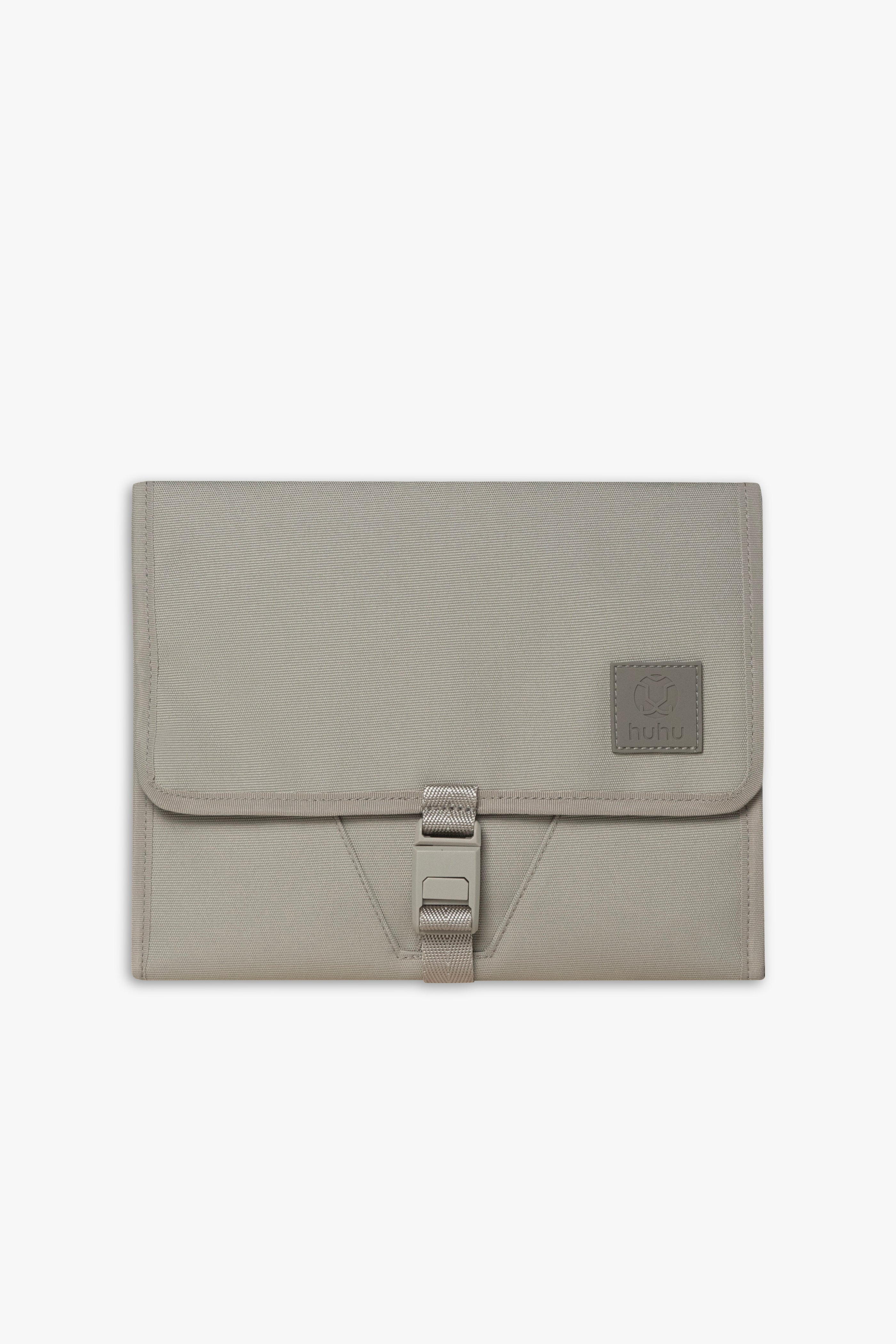 Front view of closed taupe changing wallet against a white background.